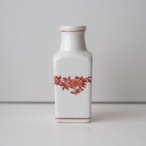 粵東磁廠（Yuet Tung China Works）で購入した小さな花器。白い磁器に朱色でペニンシュラ柄と呼ばれる絵付けがされている。角形で口がすぼまった、ウイスキーの瓶のような形状。